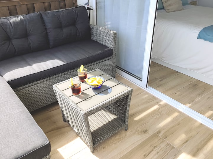 Eneo la kupumzika kwenye mtaro na sofa ya Chaislongue na meza ya kahawa.