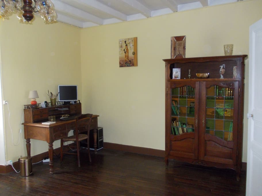 Un bureau avec ordinateur, jeux, livres... et clic-clac.