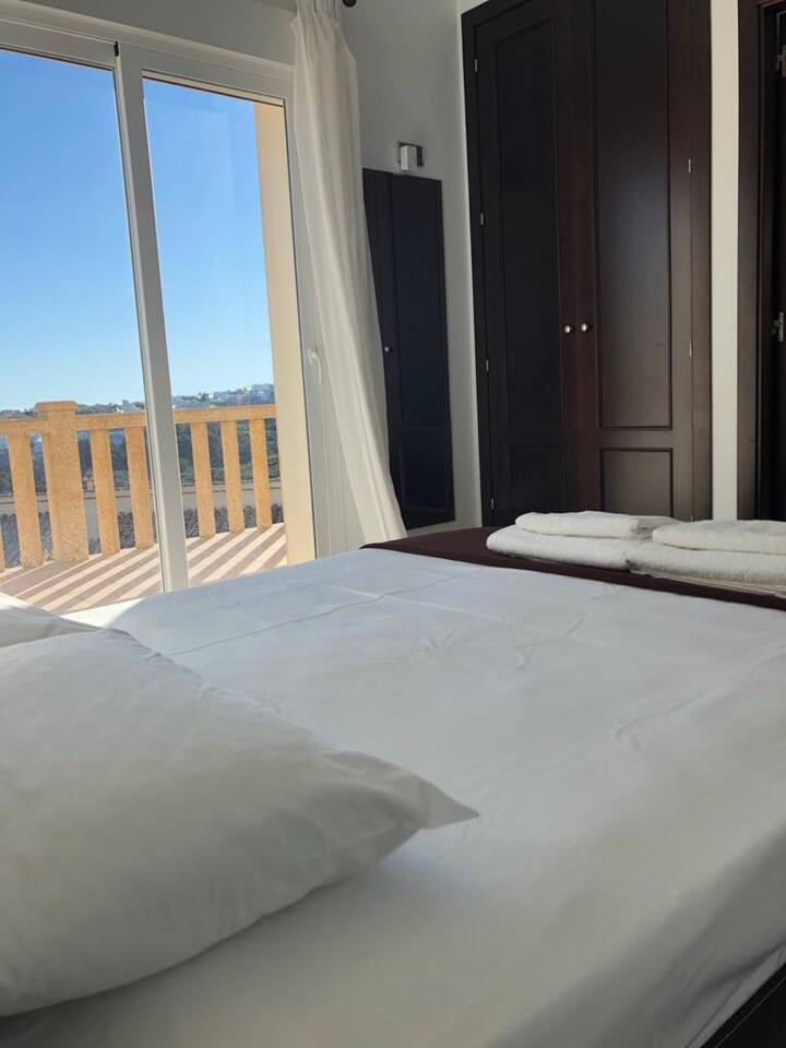 ห้องนอนคู่ตรงไปยังระเบียงและบริเวณสระว่ายน้ำ ห้องนอนทุกห้องมีตู้เสื้อผ้าและโต๊ะข้างเตียงในตัว