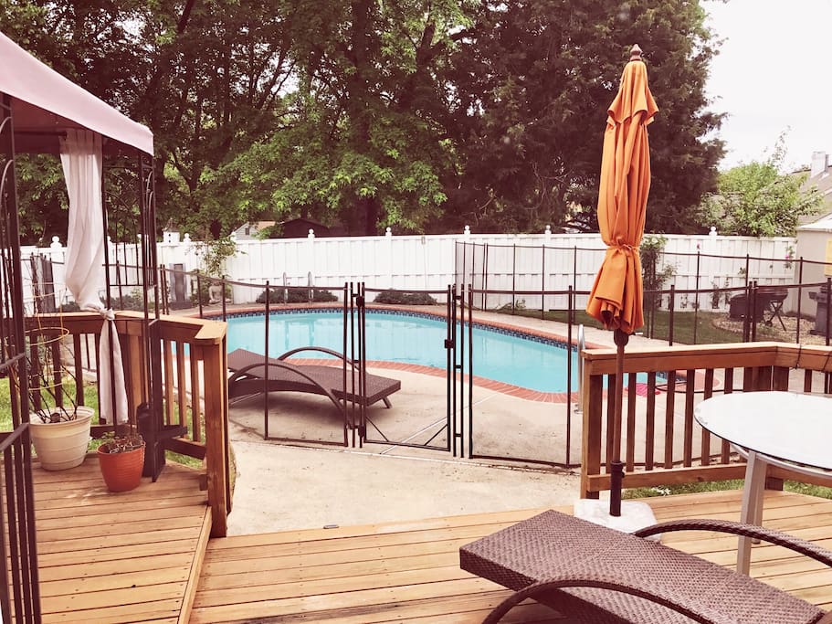 Beautiful pool with child safety fence, deck in fenced in back yard with pergola sun loungers, outdoor dining and coffee furniture.