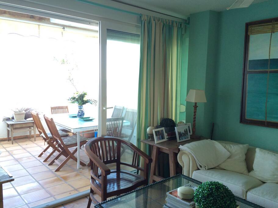 Salón con sofá de 8 plazas, mesa de centro , dos butacas y comedor para 6 con ventanal de puerta corredera dando a la terraza, mucha luz y unas vistas impresionantes.