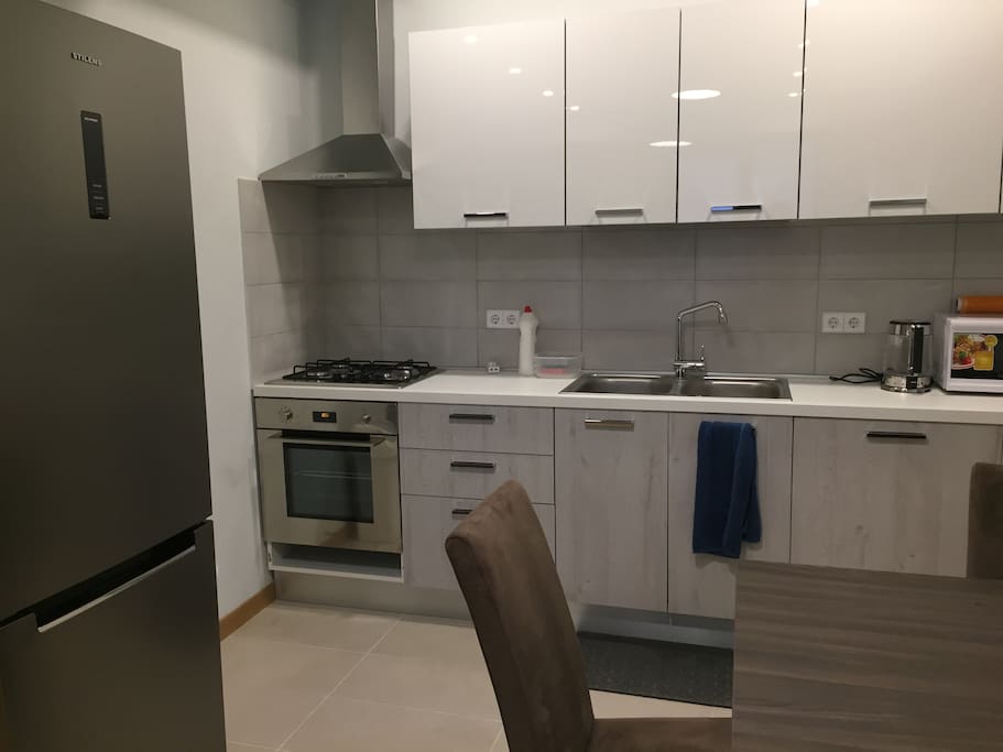 Convenient kitchen with all necessary kitchenware, microwave, oven, dishwashing machine, etc.