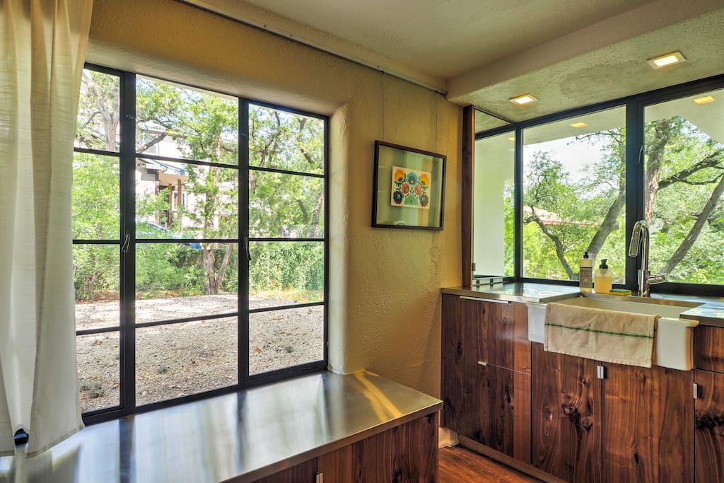 The bright fully equipped kitchen boasts vibrant treetop views!