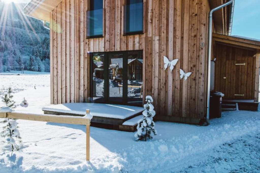 Voorkant chalet in de winter met terras bij de keuken