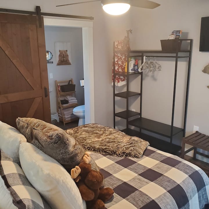 dormitorio con sábanas proporcionadas, armario abierto y televisor de 32pulgadas.
