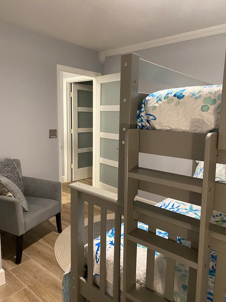 Chumba cha kulala cha wageni wawili kina maghorofa mapya. Pacha juu ya magodoro kamili yaliyo na kitanda kamili chini yake. Kiti cha kusoma. Sliders open to pool/spa lanai. Nzuri sana kwa watoto, vijana, au watu wazima. Magodoro yote na matandiko mapya mwaka huu. 