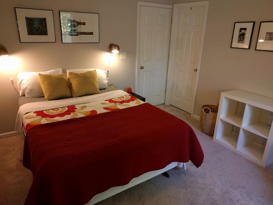 Comfortable queen bed with sconce bedside lighting, storage cubbies.
