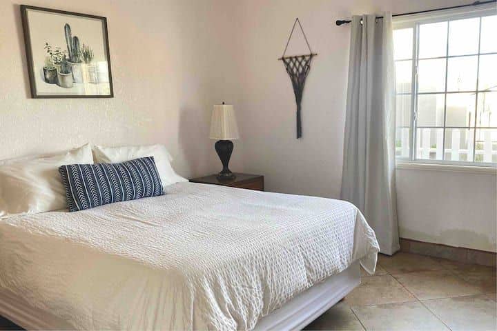 2e slaapkamer met een queensize bed en kast. 