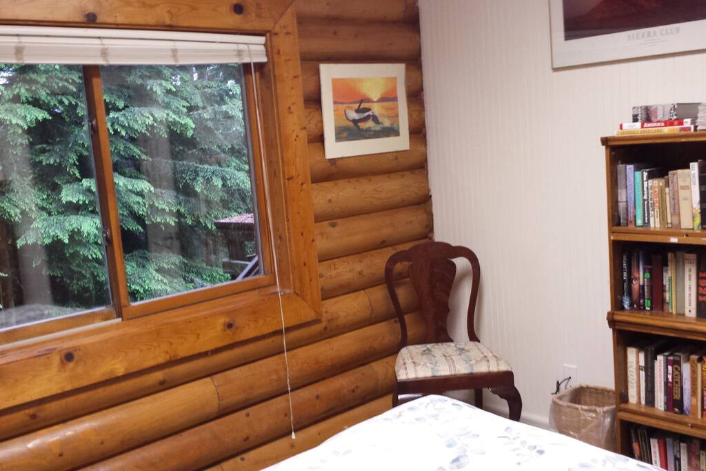 The large window in the Garden View guest room overlooks the back yard, garden, and spruce trees.