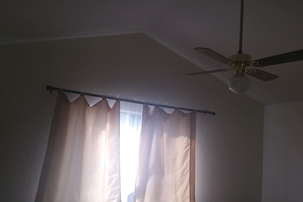 Vaulted ceiling, fan and window in the room