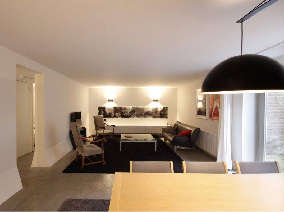 The living room has comfy chairs and a TV.