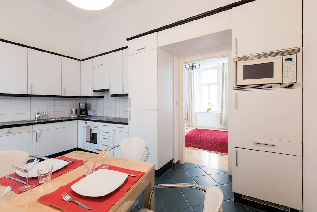 kitchen with dining area with view to 2nd bedroom with coffee machine, microwave and dishwasher
