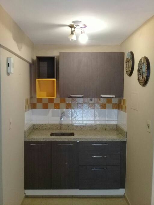 La cocina renovada cuenta con heladera, microonda, un lavadero y cubiertos