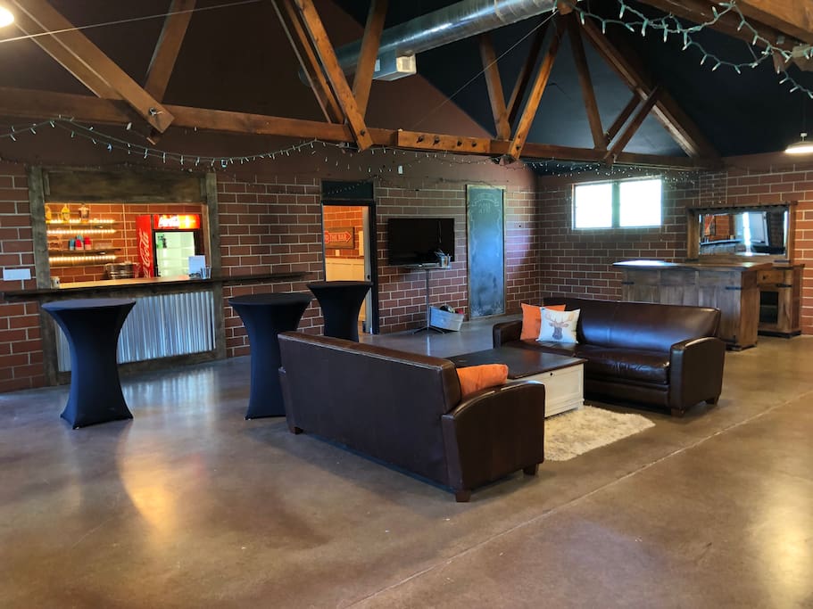 Main event room w 2 bars, lounge area, 55” tv/monitor, photo booth area.