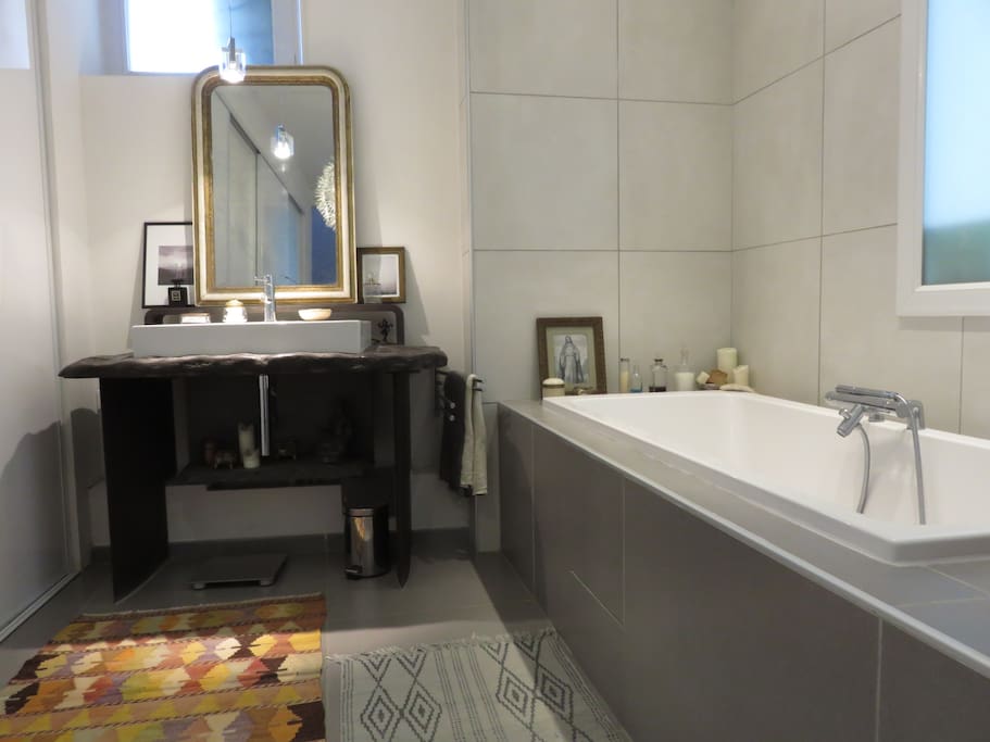 La salle de bain avec une grande baignoire