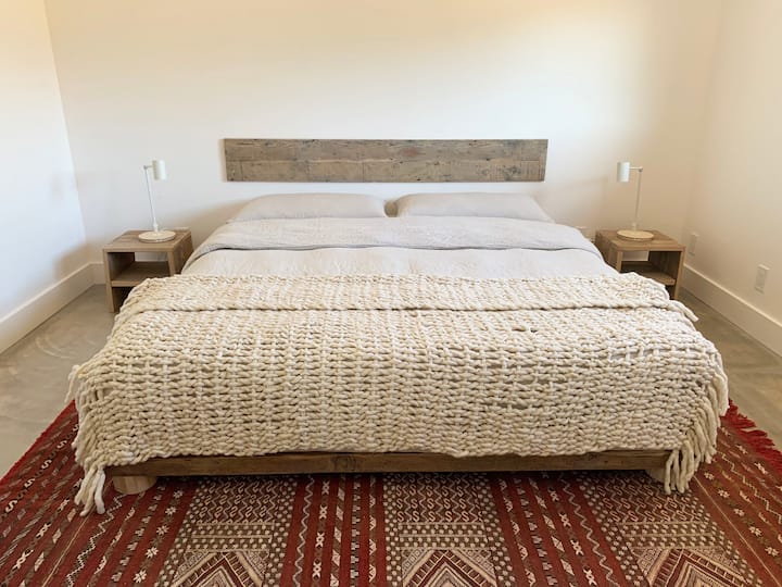 חדר שינה 2: מיטת קינג סייז וכריות מעל שטיח מרוקאי. ערב חיוב אלחוטי עומד בכל צד. 