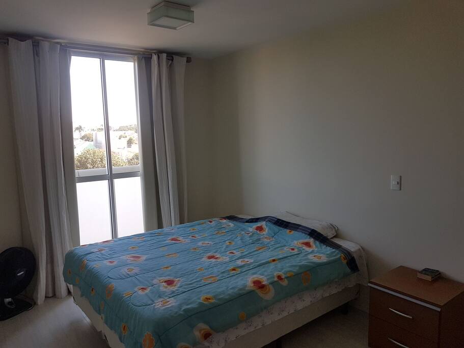 Quarto com camal de casal Queen size e criado mudo.