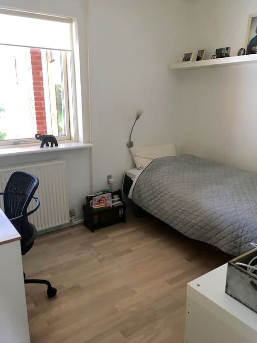 Værelse med enkeltseng og skrivebord.
