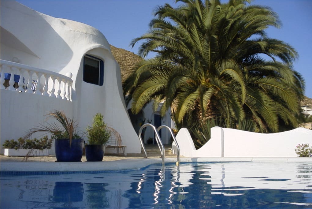 A white Gaudi house with blue surroundings