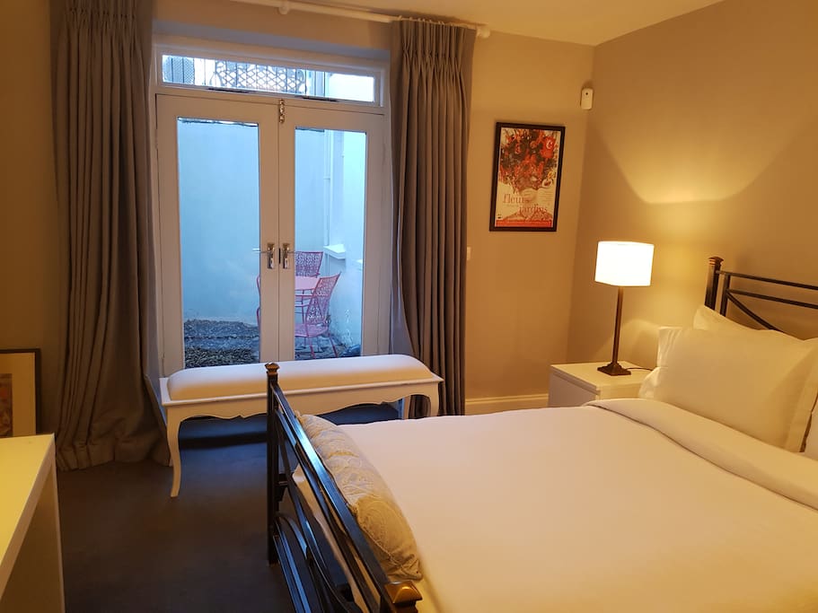 Bedroom with Queen bed, large sofa, and private patio