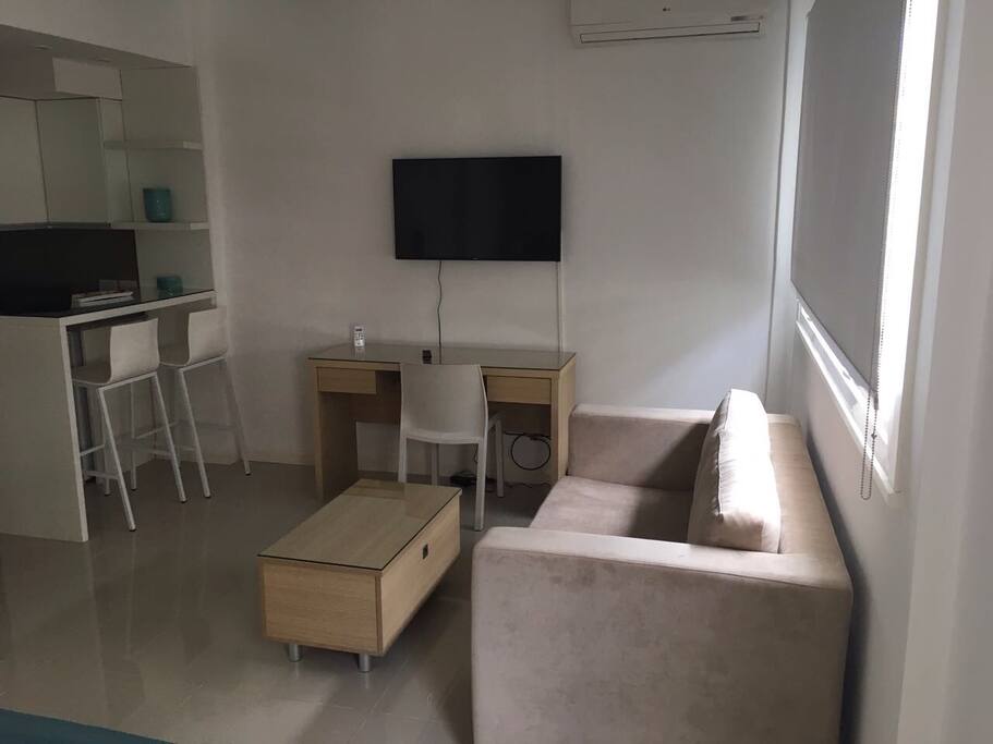 Vista del estudio desde la cama. Mesa ratona con frazada en su cajón.