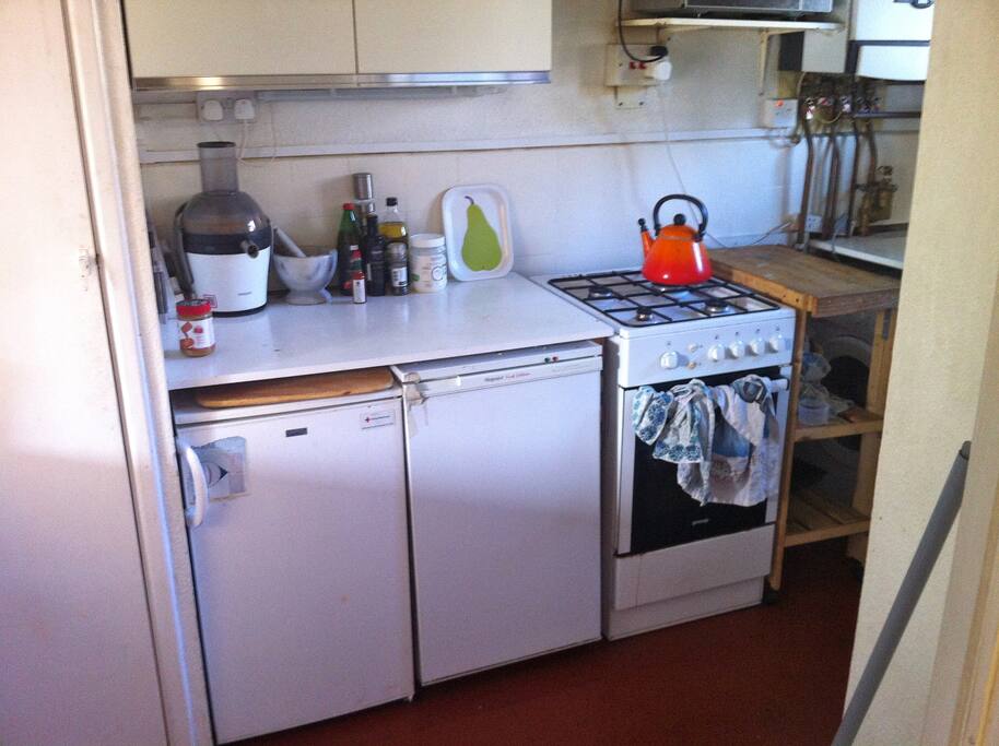 Kitchen with cooker, kettle, microwave, fridge, freezer and washing machine.
