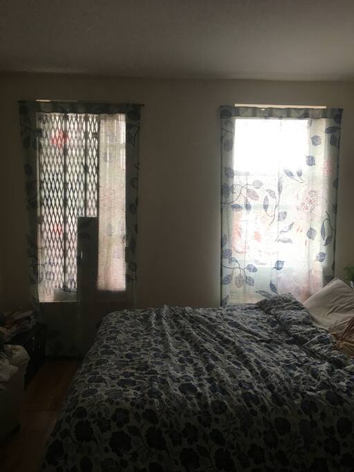 Beautiful, king-sized bedroom with two large windows, a walk-in closet, and in-unit air conditioning. Comfortable and cozy queen-sized bed.