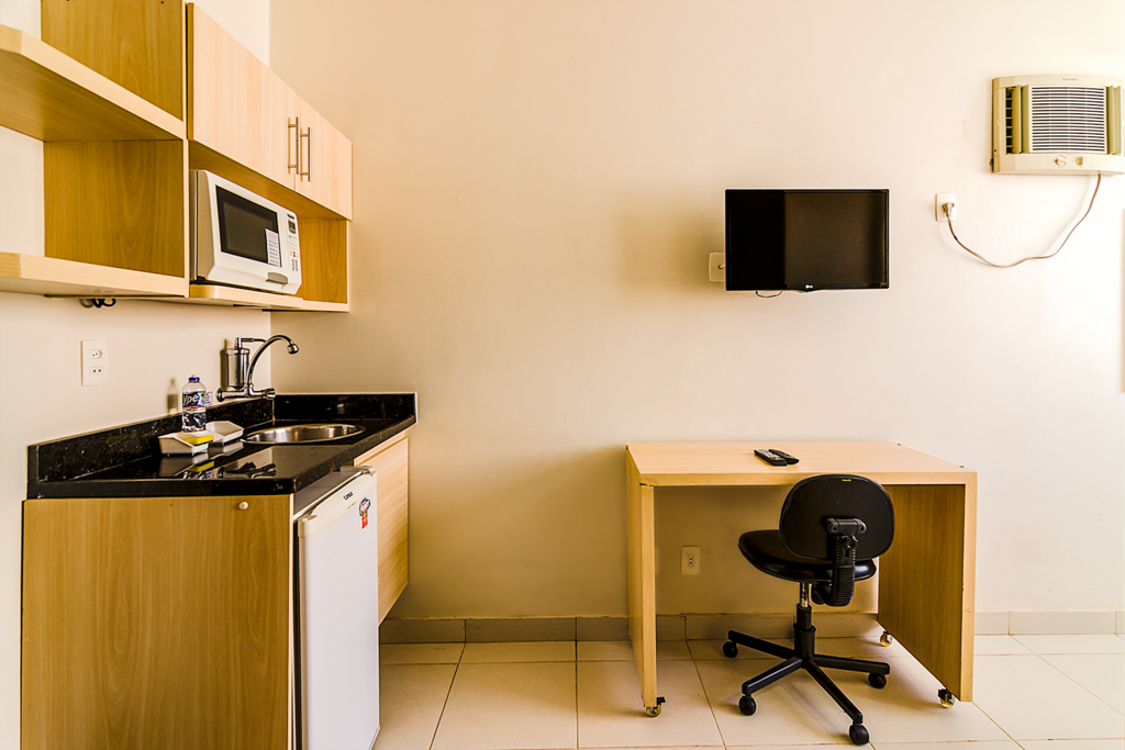 A suíte possui uma mini copa, TV LED 28", ar-condicionado e mesa de estudo.