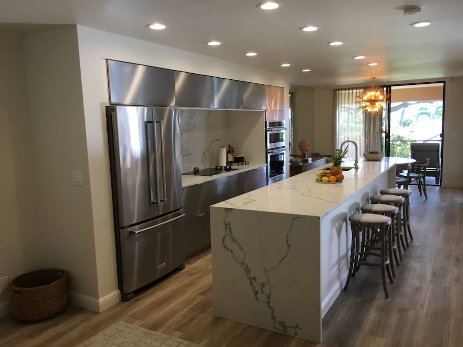 Newly remodeled kitchen with stainless steel appliances and marble counters.