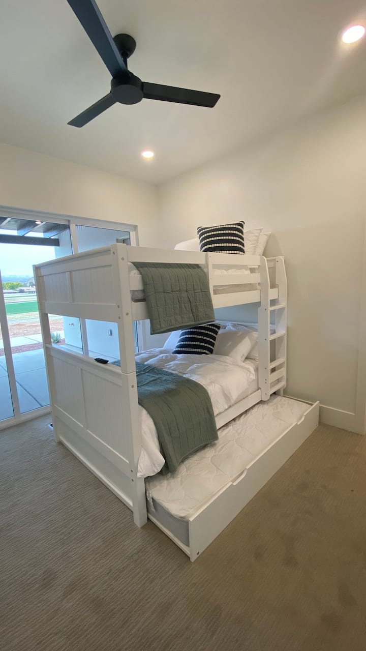 Dormitorio2: puede dormir 3 personas, con 2 literas tamaño queen y un colchón extraíble adicional debajo. Este dormitorio tiene una puerta corrediza de cristal que tiene acceso al patio y vistas al agujero #18.