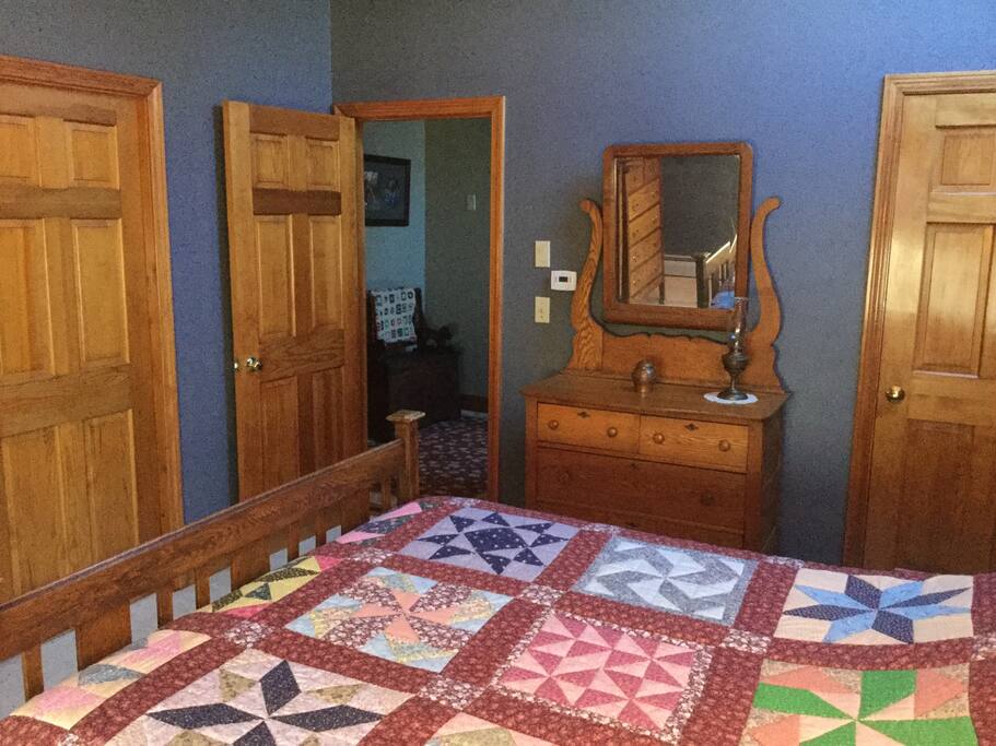 Antique oak dresser with mirror, closet door to the right, bedroom door opens to upstairs landing.