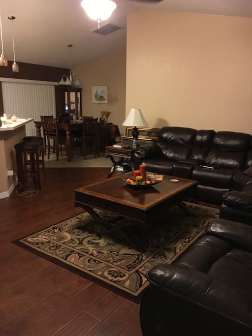 Shared living room space with large leather sectional, coffee table, and television with Netflix