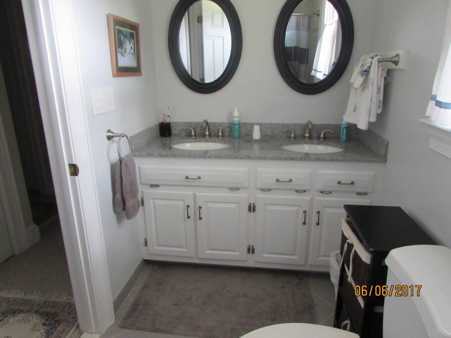 Bathroom with double sink and shower. This bathroom is in the hall and maybe shared.