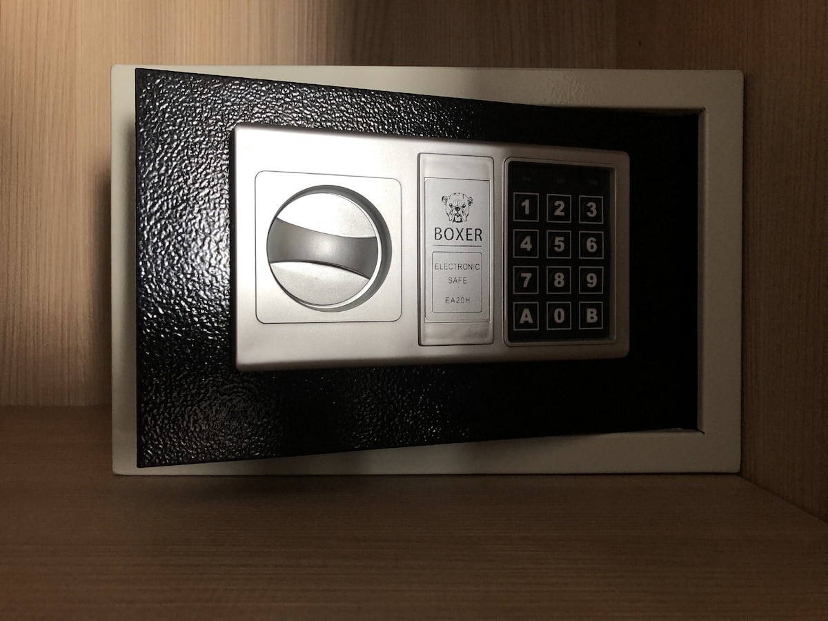 An electronic safe is installed within a wooden cabinet. The safe features a numeric keypad and a round dial, designed for secure storage of valuables.