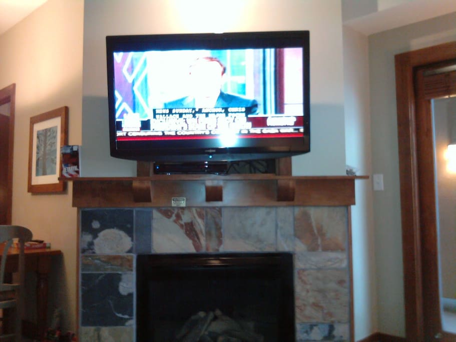 New 47" HDTV w/ Blue-Ray/DVD player, with the gas fireplace below and glass door to the balcony to the right. 15 or so DVD's on shelf for your viewing.