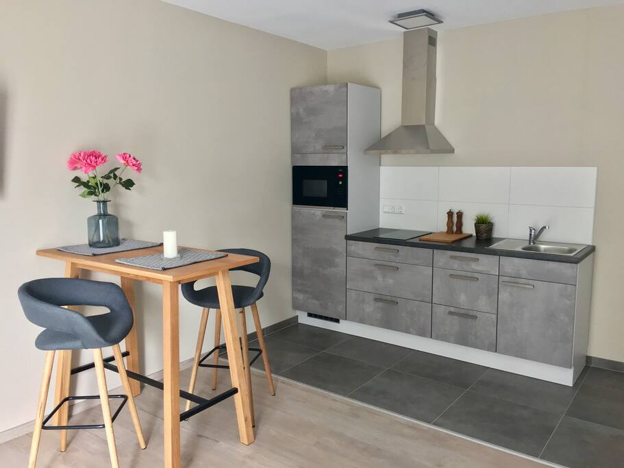 Essbereich mit Einbauküche Mikrowelle Kühlschrank Cerankochfeld