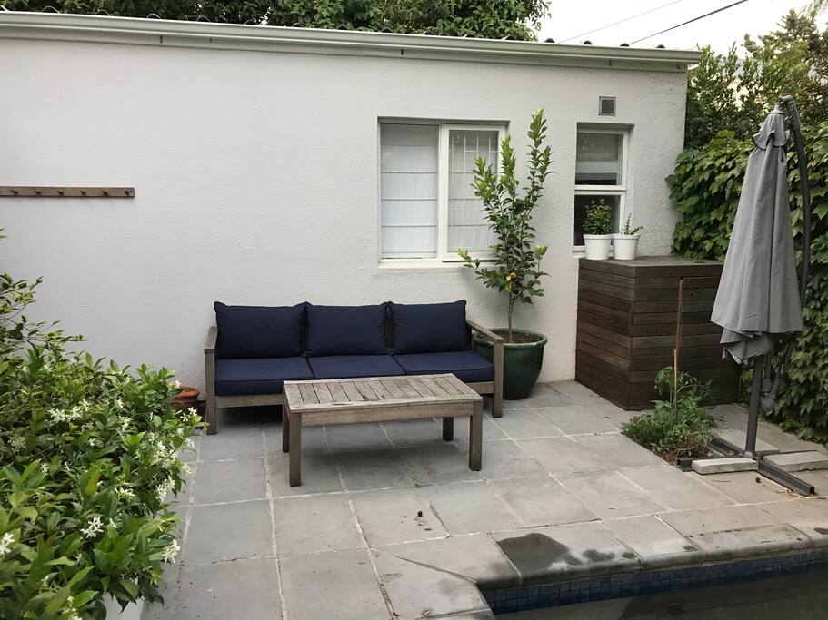 Outside pool area with couch and table, next to heated pool