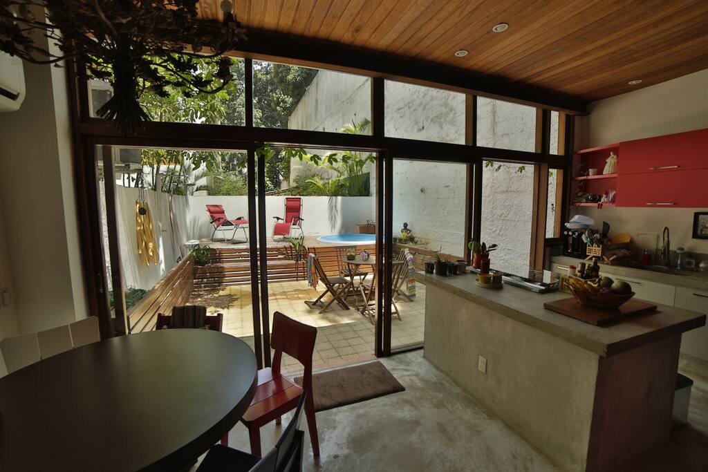 Open the glass doors to the singing songs of the lush jungle of Alto Leblon