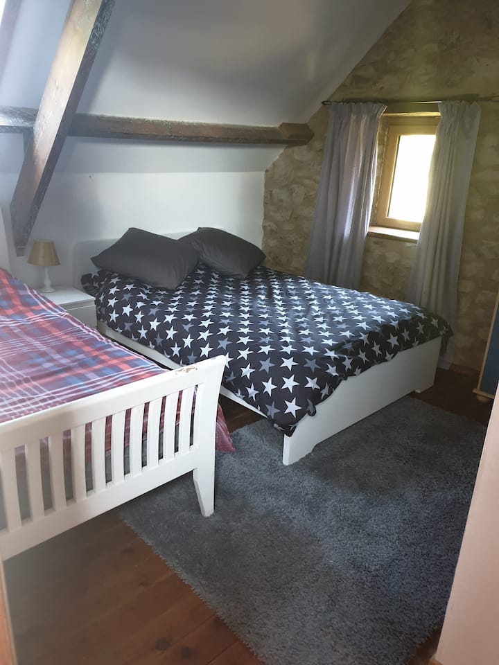 غرفة نوم في الطابق العلوي مع حمام داخلي وسرير فردي وثنائي