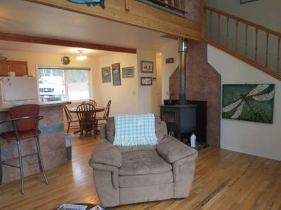 Spacious living room with cathedral ceilings, decorated with Alaskan decor, matched with stunning views of the Kasilof River right out your back door.