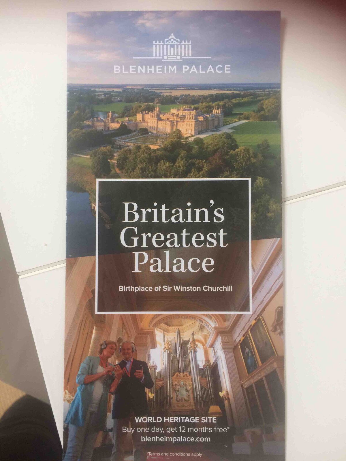 A promotional brochure displays a scenic aerial view of Blenheim Palace, highlighting its grand architecture and sprawling grounds. The text emphasizes its significance as a UNESCO World Heritage Site and the birthplace of Sir Winston Churchill.