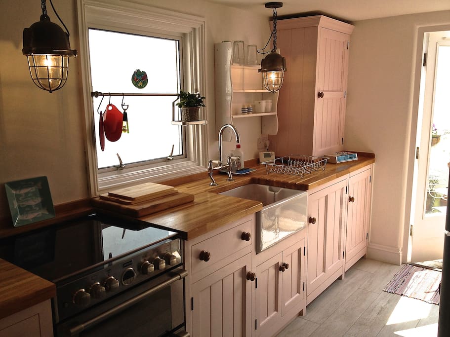 Bright bespoke kitchen with cooker, microwave, fridge/freezer, washing machine & dishwasher. Leads to sunny balcony.