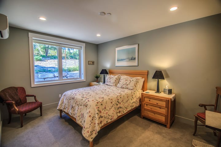 חדר שינה לאורחים עם מיטת קווין סייז ואזורי ישיבה וארון