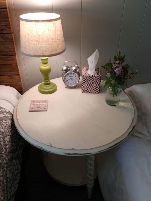 side tables, lamp, tissue, fresh flowers, alarm clock and coaster.