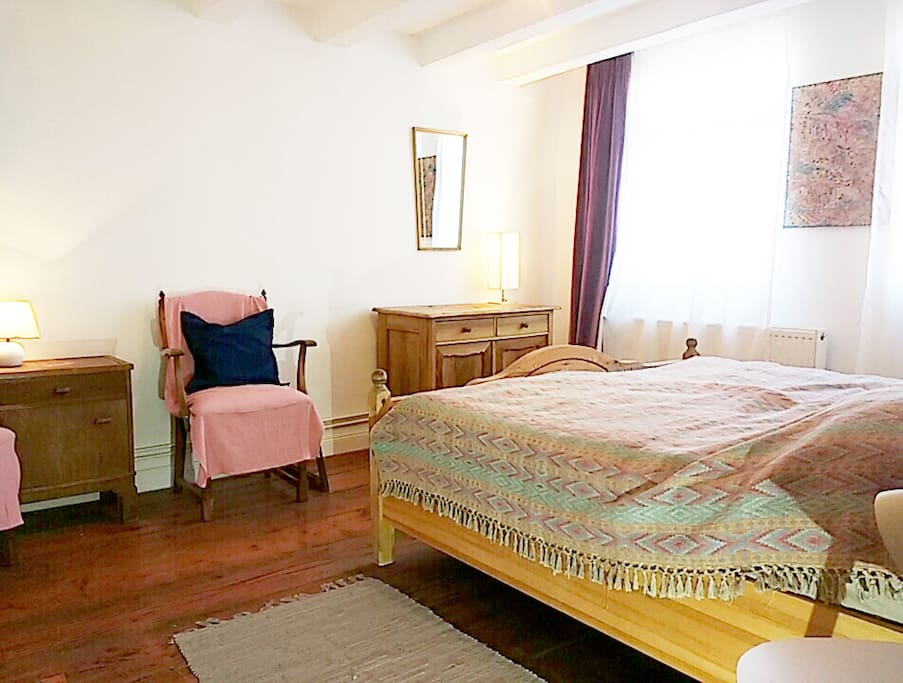 individuell eingerichtetes Zimmer mit Doppelbett