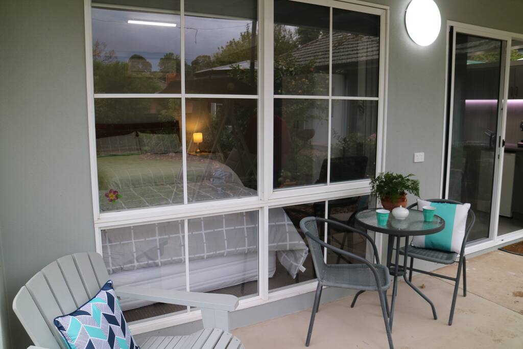 Covered porch with table and chairs.