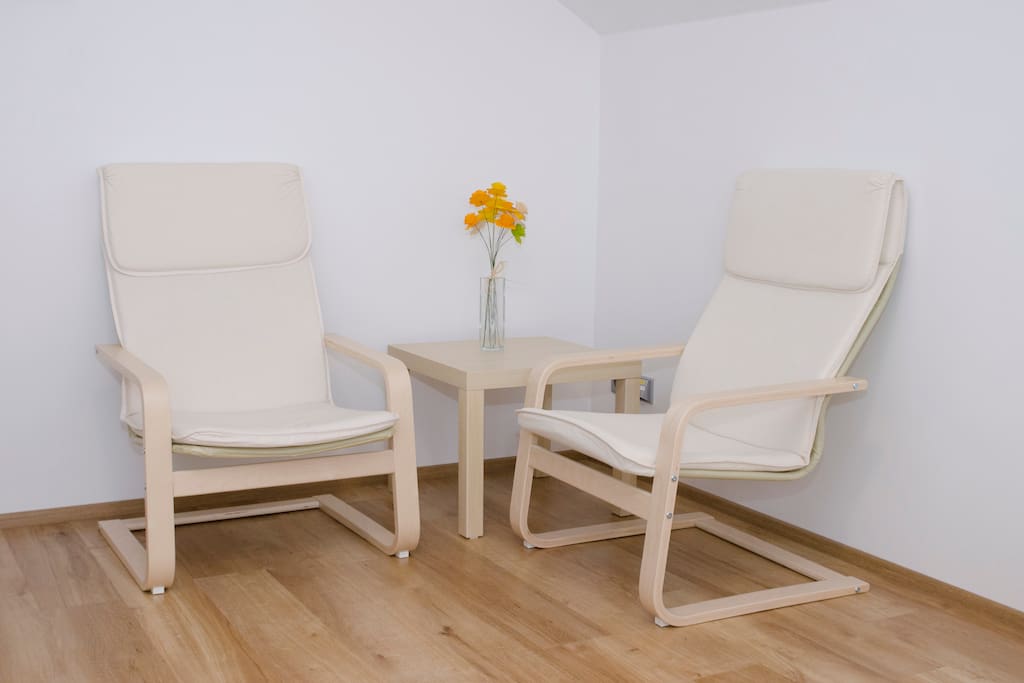 Pokoj pro hosty / Guest room with two chairs and a conference table