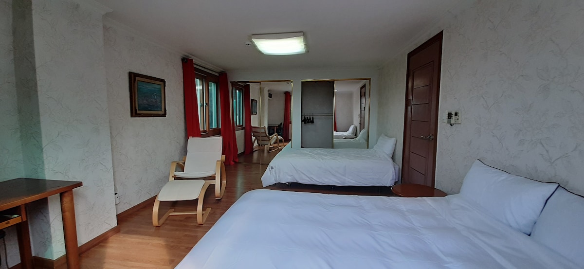 Il s'agit d'une chambre.
Il y a un lit queen size, un lit super simple et un bureau où vous pouvez voir le bureau afin que 3 personnes puissent l'utiliser. 