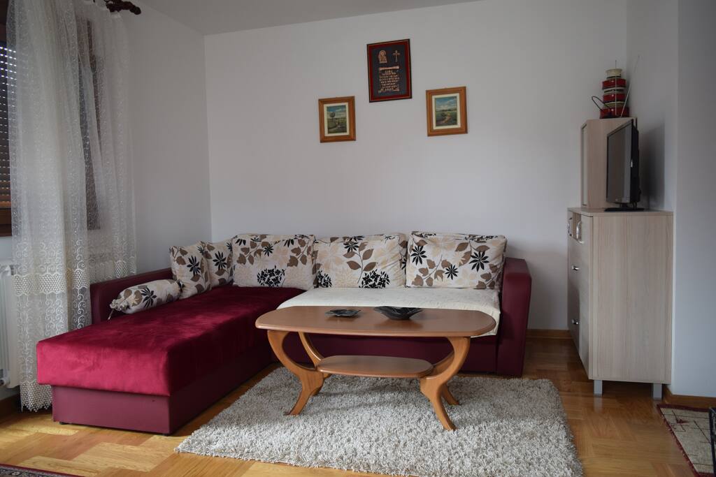 The comfy sofa with the TV.