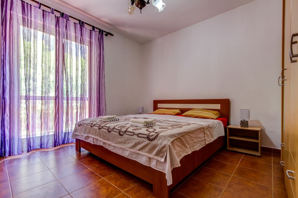 Bedroom with double bed and balcony with mountain view